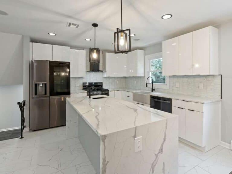 Bancada de cozinha moderna em mármore branco com veios cinzas, destacando a elegância e luminosidade.